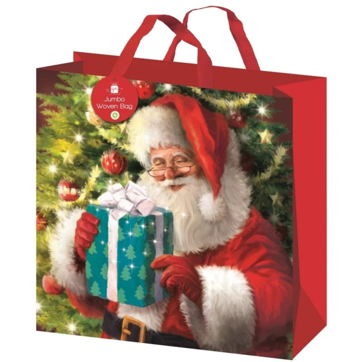 Christmas gift bag with Santa Claus holding a gift in front of a decorated tree.