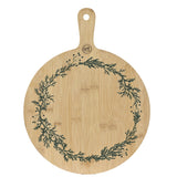 Round wooden cutting board with green leaf pattern on a white background