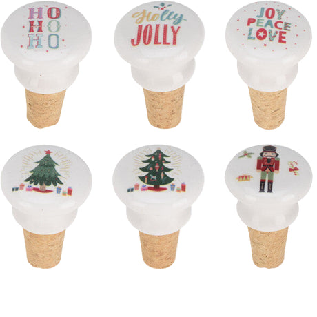 Set of Christmas-themed bottle stoppers with 'HO HO HO' and other festive designs, displayed with a cardboard box.