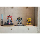 Three robot toy figures on a concrete surface with a minimal background