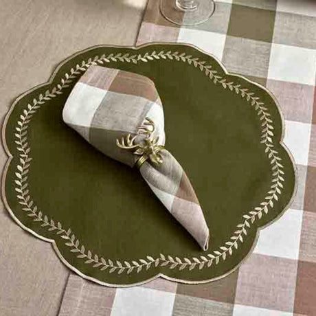 Green placemat with a folded checkered napkin and decorative element on a checkered tablecloth.